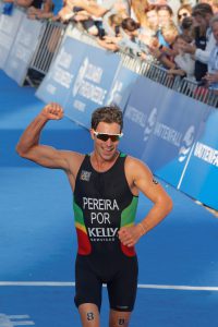 Smiling triathlete Joao Pereira raising his fist after the finis